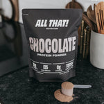 Chocolate protein powder bag and scoop on counter